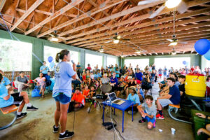 A woman addresses families at a Generation Serve youth volunteer program in Texas.