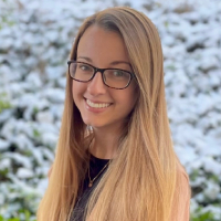 Dr. Lydia Colvin, a youth volunteer program leader in Texas, smiles outdoors in winter.