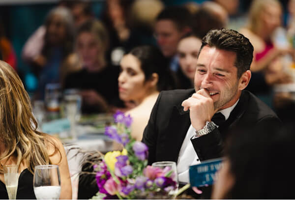 A man at a fundraising gala supports youth volunteer programs in Texas.