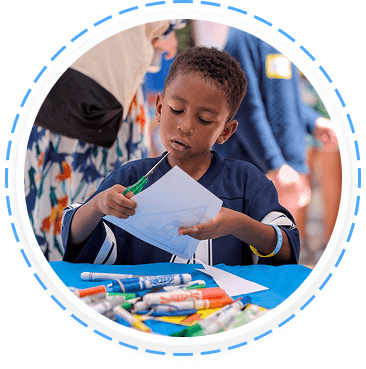 A young boy draws during a youth volunteer program at our Texas family volunteering event.
