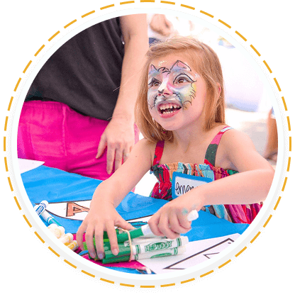A girl creates art at a teen service volunteer program in Texas, smiling brightly.