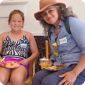 A teen and adult share a meal at a youth volunteer event in Texas, wearing name tags.