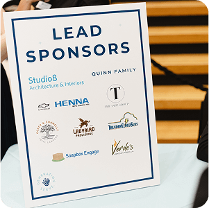 A table sign highlights sponsors supporting youth and family volunteering in Texas.