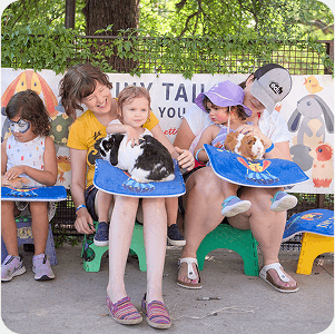 Youth and adults in a family volunteering program care for animals outdoors in Texas.