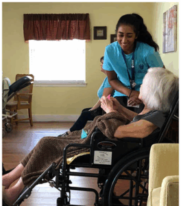 A teen volunteering in Texas chats with an elderly woman during a service program.