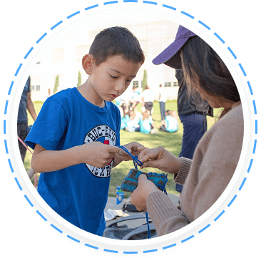A young boy and adult engage in outdoor youth volunteer activity in Texas.