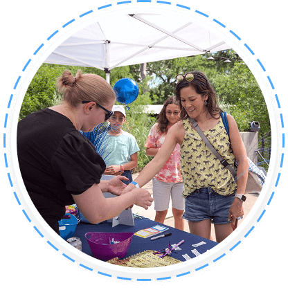 A young woman joins a youth volunteer program at an event booth in Texas.