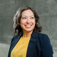 Smiling woman in business attire represents youth volunteer programs in Texas.