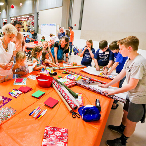 Teens and families volunteer in Texas, making crafts for youth service programs.