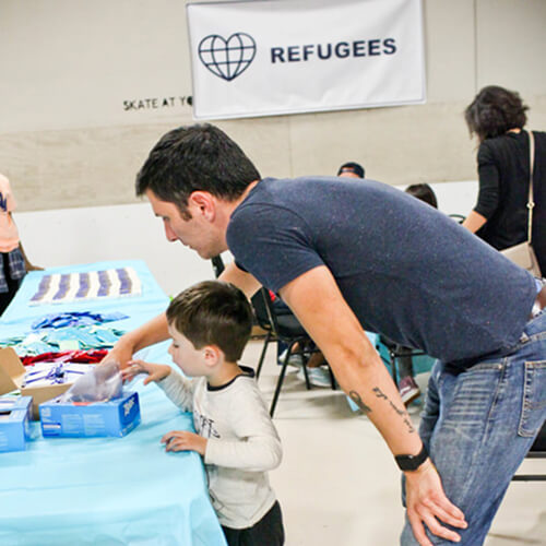 A teen and adult volunteer at a family volunteering event in Texas for refugees.