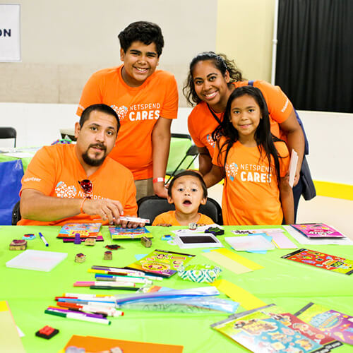 Teens and families volunteer in Texas art program, smiling during youth service.