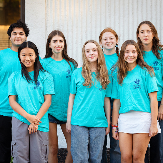 Seven teens in "Serve" shirts pose outside, representing youth volunteer programs Texas.