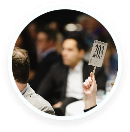 Teen volunteer holds paddle 203 at youth volunteering auction, Texas family service event.