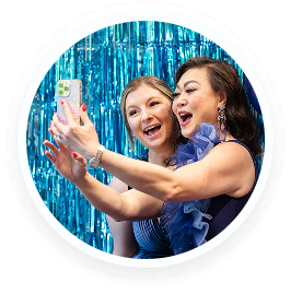 Two women in evening attire take a selfie at a youth volunteer programs Texas event.