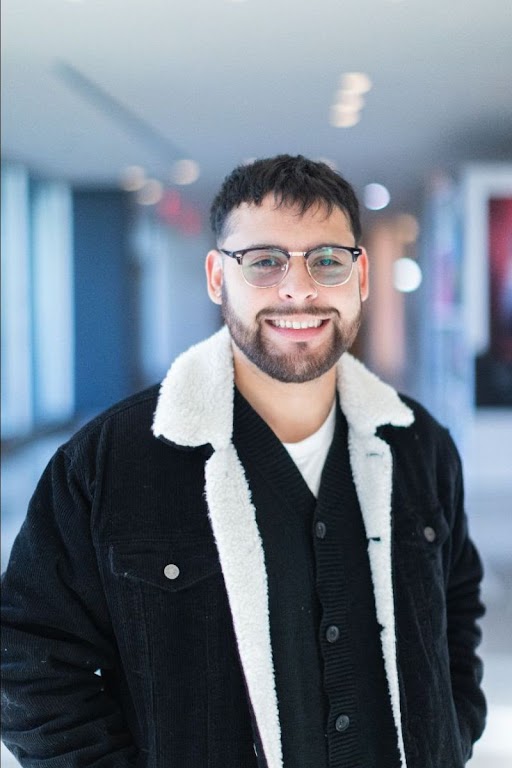 Christian Mendoza, youth volunteer, smiles in a bright hallway at a Texas teen service program.